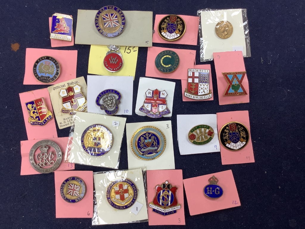 A collection of assorted enamel badges and nursing badges